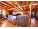 Spacious kitchen with wooden beams, modern appliances, center island, and open concept design to the dining area and living area at 6980 Lamplighter Ln, Winston, GA 30187