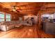 Spacious living area boasts wood beam ceilings, modern kitchen with island, and comfortable seating with view of the staircase at 6980 Lamplighter Ln, Winston, GA 30187