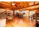 Open living area features wood beam ceilings, kitchen with island, and a cozy living room with sectional sofa at 6980 Lamplighter Ln, Winston, GA 30187