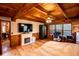Cozy main bedroom featuring wood-paneled walls, ceiling beams, a decorative fireplace, and a comfortable workspace at 6980 Lamplighter Ln, Winston, GA 30187