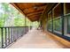 Expansive porch with rocking chairs, wood floors, and serene wooded views at 6980 Lamplighter Ln, Winston, GA 30187