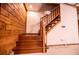A wooden stairway featuring exposed wooden walls ascends to the upper level at 6980 Lamplighter Ln, Winston, GA 30187