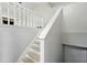 Well-lit staircase featuring neutral walls, a white banister, and wood-look treads at 193 Cedar Creek Dr, Dallas, GA 30157
