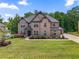 Two-story brick home showcasing a well-manicured lawn and beautiful landscaping at 317 Basel Way, Hampton, GA 30228