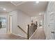 Upstairs hallway featuring plush carpet, neutral walls, and wooden railing at 317 Basel Way, Hampton, GA 30228