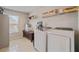 Bright laundry room with shelving, tile floors, and a window for natural light at 317 Basel Way, Hampton, GA 30228
