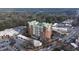 View of a brick high rise building with a green roof surrounded by streets and full parking lots and wooded areas at 3820 Roswell Ne Rd # 705, Atlanta, GA 30342