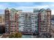 Multi-story condo building with green roofing, brick and white facade, and multiple balconies at 3820 Roswell Ne Rd # 705, Atlanta, GA 30342