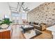 Stylish living room featuring exposed brick wall, hardwood floors, and large windows at 3820 Roswell Ne Rd # 705, Atlanta, GA 30342