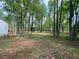 View of a house featuring a spacious wooded backyard with mature trees and a deck at 7160 Royston Way, Cumming, GA 30028