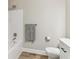 Bathroom showing tub/shower with grey towel and white toilet at 7160 Royston Way, Cumming, GA 30028