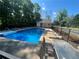 Community swimming pool features lounge chairs, shaded seating, and a fenced perimeter at 7160 Royston Way, Cumming, GA 30028