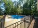 Large community swimming pool with lounge chairs, table, and a secure fenced perimeter at 7160 Royston Way, Cumming, GA 30028