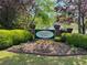 Bannister Park sign with landscaping and colorful flowers located at the entrance to the community at 7160 Royston Way, Cumming, GA 30028
