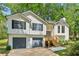 Charming two-story home with white siding, a two-car garage, and surrounded by lush greenery at 7160 Royston Way, Cumming, GA 30028