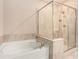 Bright bathroom featuring a soaking tub, separate shower with glass doors, and tile surround at 305 Duval Dr, Alpharetta, GA 30009