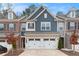 Beautiful townhouse with blue accents, brick accents, two-car garage and a paved driveway at 305 Duval Dr, Alpharetta, GA 30009