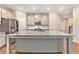 Bright kitchen featuring an island with a stone countertop, stainless steel appliances, and shaker cabinets at 305 Duval Dr, Alpharetta, GA 30009