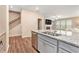 Open kitchen showcasing a granite island with a sink, shaker cabinets, and a view into the living room at 305 Duval Dr, Alpharetta, GA 30009
