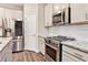Updated kitchen featuring stainless steel appliances, a gas range, white subway tile, and shaker cabinets at 305 Duval Dr, Alpharetta, GA 30009