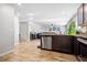 View of kitchen island with sink, leading to the living room, with stainless steel appliances, and dark cabinets at 400 Toronto Cir, Hampton, GA 30228