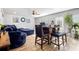 Open concept living area features a stylish dining table, cozy blue sofa, and well-lit space for relaxation at 400 Toronto Cir, Hampton, GA 30228