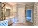 Bathroom featuring a large mirror, cabinets, and floral wallpaper at 4481 Mccart Cv, Stone Mountain, GA 30083