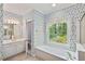 En-suite bathroom with garden tub, white cabinetry, and large window at 4481 Mccart Cv, Stone Mountain, GA 30083