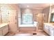 Bright bathroom with a garden tub, shower, and floral wallpaper at 4481 Mccart Cv, Stone Mountain, GA 30083