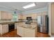 Well-lit kitchen with stainless steel refrigerator, granite countertops, and wood cabinets at 4481 Mccart Cv, Stone Mountain, GA 30083