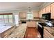 Well-lit kitchen boasting granite countertops, stainless steel appliances and hardwood flooring at 4481 Mccart Cv, Stone Mountain, GA 30083