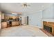 Bright living room with fireplace open to the kitchen, carpeted, and with traditional ceiling fan at 4481 Mccart Cv, Stone Mountain, GA 30083