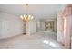 Spacious living room with light carpet, a chandelier, and traditional-style decor at 4481 Mccart Cv, Stone Mountain, GA 30083