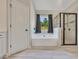 Modern bathroom with a garden tub, glass enclosed shower and wood-look tile floors at 47 Whitley Ct, Dallas, GA 30157