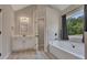 Modern bathroom featuring a soaking tub, large window, and a double sink vanity at 47 Whitley Ct, Dallas, GA 30157