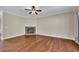 A cozy living room features hardwood floors, a ceiling fan, and a stone fireplace at 47 Whitley Ct, Dallas, GA 30157