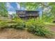 Backyard view of a two story house with deck surrounded by lush trees and vegetation at 563 Navarre Dr, Stone Mountain, GA 30087