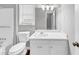 Clean bathroom with a white vanity, toilet, and a large mirror offering ample light at 563 Navarre Dr, Stone Mountain, GA 30087