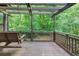 View of the wooden deck featuring a swing, pergola, and lush green surroundings at 563 Navarre Dr, Stone Mountain, GA 30087