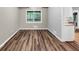 Cozy dining area with wood-look flooring, a large window, and access to the kitchen and backyard at 563 Navarre Dr, Stone Mountain, GA 30087