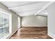 Spacious living room with vaulted ceilings, exposed beams, sleek wood-look flooring, and natural light at 563 Navarre Dr, Stone Mountain, GA 30087