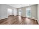 Well-lit living room featuring wood-look flooring, two windows with blinds, and fresh paint at 563 Navarre Dr, Stone Mountain, GA 30087