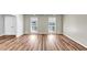 Bright living room with wood-look flooring, white trim, two large windows, and white double doors at 563 Navarre Dr, Stone Mountain, GA 30087
