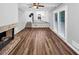 This is the living room with hardwood flooring, a brick fireplace, and access to the kitchen at 563 Navarre Dr, Stone Mountain, GA 30087