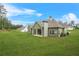 Home's exterior view highlighting a spacious lawn, covered patio, and landscaped surroundings at 100 Nemoura Ct, Fairburn, GA 30213