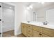 Bright bathroom with double sinks, cream-colored vanity, a mirror and a shower in the background at 100 Nemoura Ct, Fairburn, GA 30213