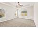 Spacious main bedroom with plush carpeting, neutral walls, tray ceiling, and abundant natural light at 100 Nemoura Ct, Fairburn, GA 30213