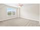Bright bedroom featuring neutral carpet, a ceiling fan, and a large window with scenic views at 100 Nemoura Ct, Fairburn, GA 30213