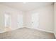 An open floorplan with neutral walls and carpet, multiple doors, and ample space for creating your ideal bonus room at 100 Nemoura Ct, Fairburn, GA 30213