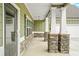 Inviting covered porch with stone columns and trim, offering a charming entry to the home at 100 Nemoura Ct, Fairburn, GA 30213